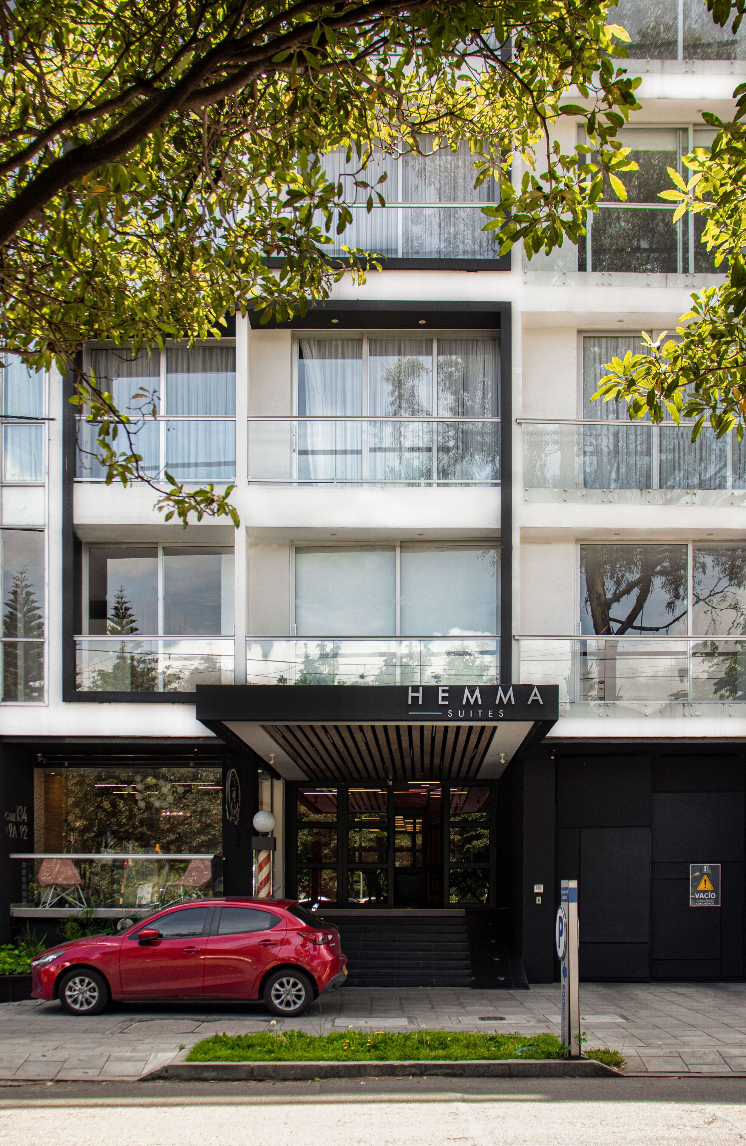 Um edifício moderno com uma placa que diz "HEMMA SUITES".