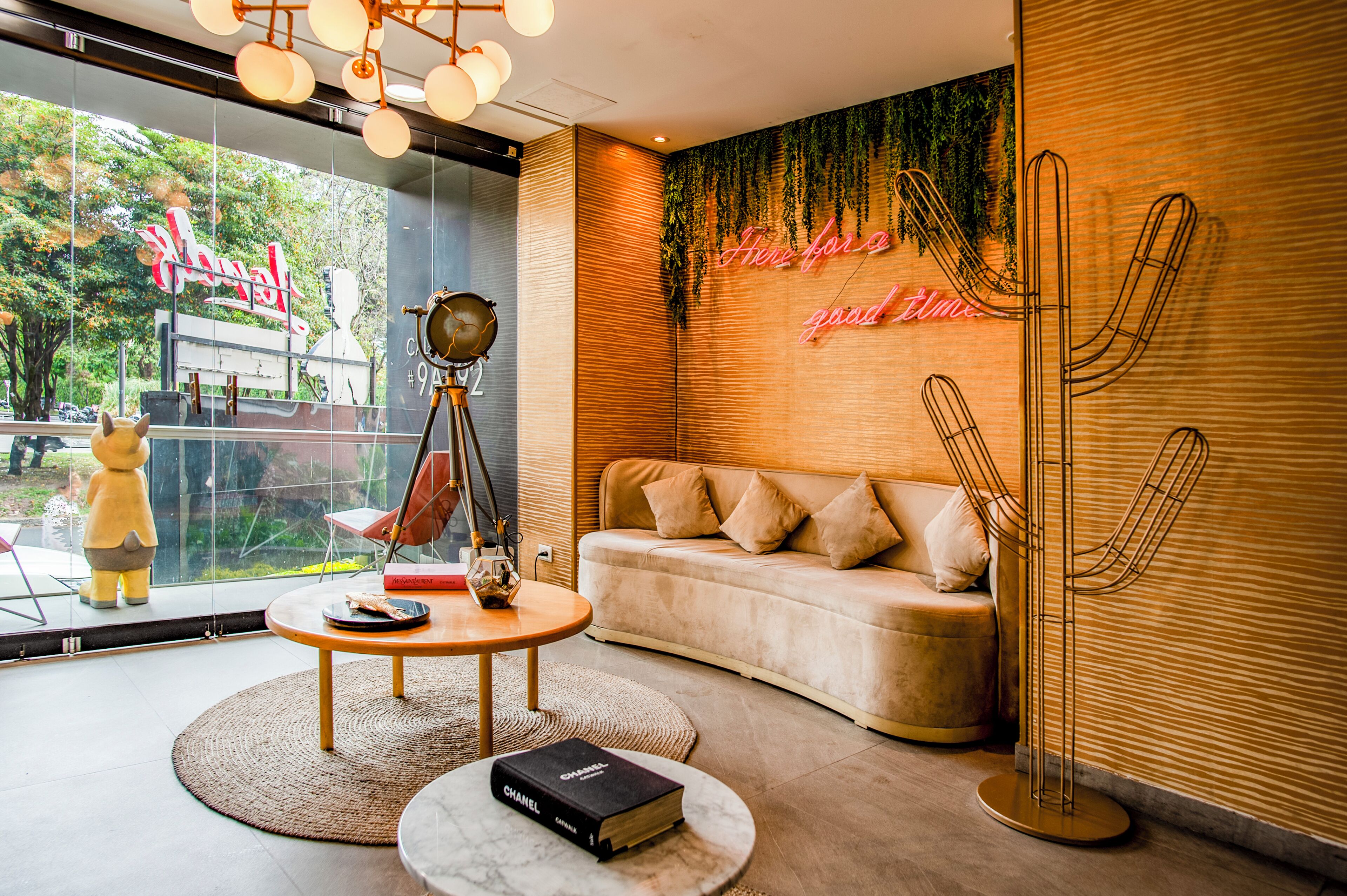 Un intérieur moderne avec un canapé, une table ronde, une lampe décorative et une sculpture en forme de cactus.