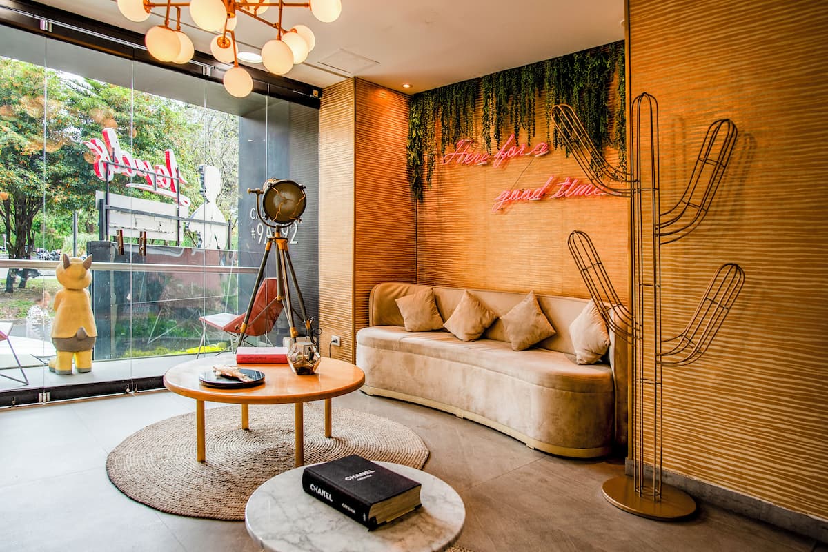 A modern interior with a sofa, a round table, a decorative lamp, and a cactus sculpture.