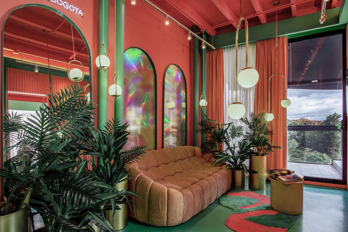 A modern living room with a large sofa, green walls, and large windows.