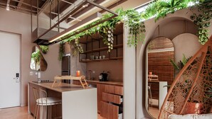 Una cocina moderna con armarios de madera, una isla central y plantas colgantes.