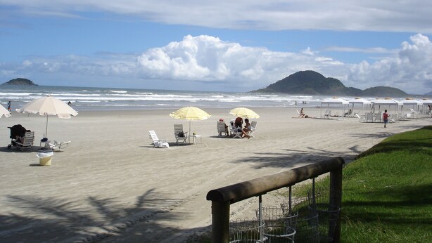 A beach with umbrellas, chairs, and a wooden fence. - BEAUTIFUL APARTMENT IN RIVIERA DE SÃO LOURENÇO, MODULE 4 (Riviera de São Lourenço)