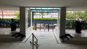 A hotel entrance with a covered walkway, steps leading to the entrance, and potted plants on either side. - BEAUTIFUL APARTMENT IN RIVIERA DE SÃO LOURENÇO, MODULE 4 (Riviera de São Lourenço)