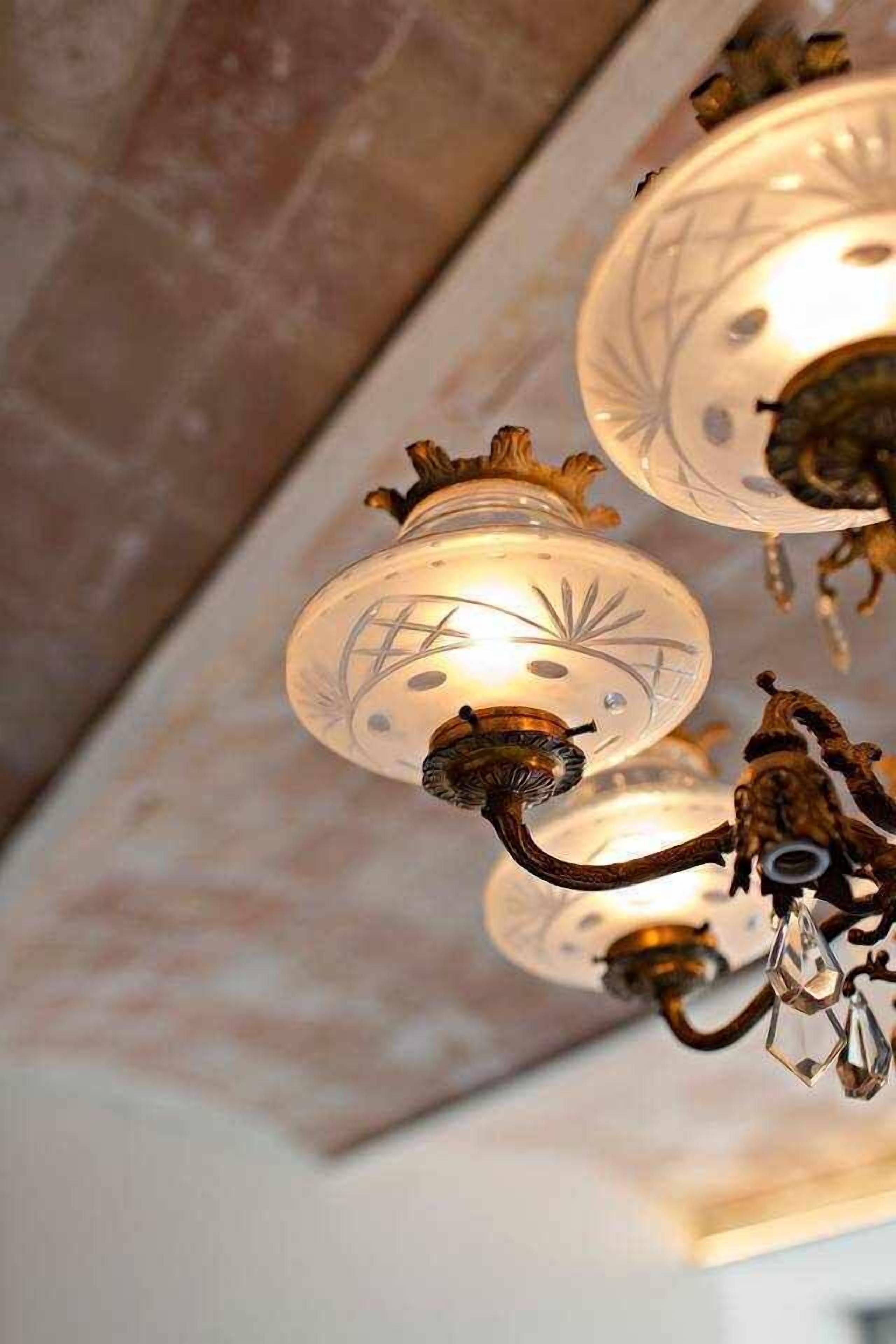 Un candelabro con múltiples pantallas de vidrio y detalles de cristal.