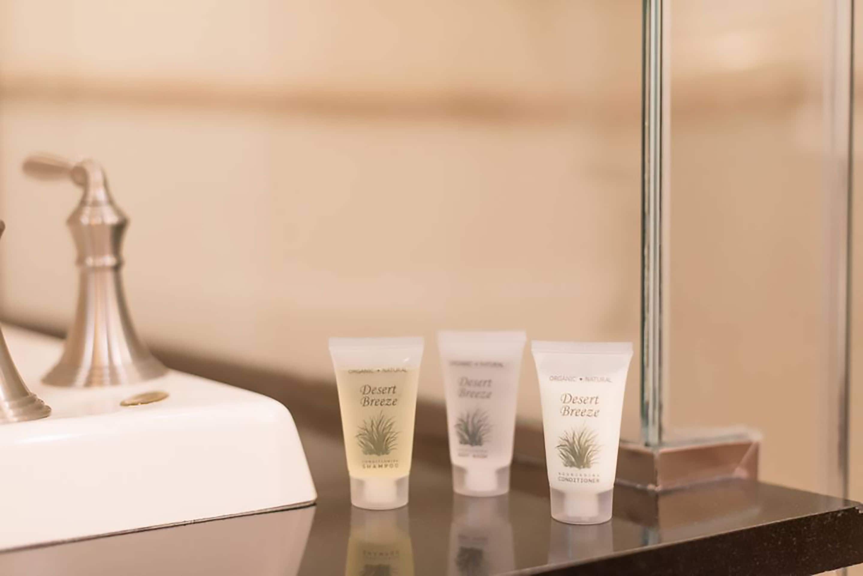 Three tubes of Desert Breeze shampoo and conditioner on a bathroom counter.