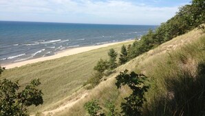 A coastal landscape with a sandy beach, grassy dunes, and a view of the ocean. - Luxury Harbor Front Home In Town Chef's Kitchen 4 Ensuite King Rooms + 1/2 bath (Saugatuck)