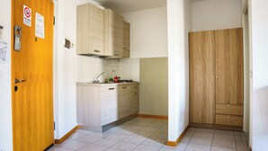 A small kitchen with light wood cabinets, a stainless steel sink, and a tiled floor. - Studio in the city center with private parking (AREZZO)