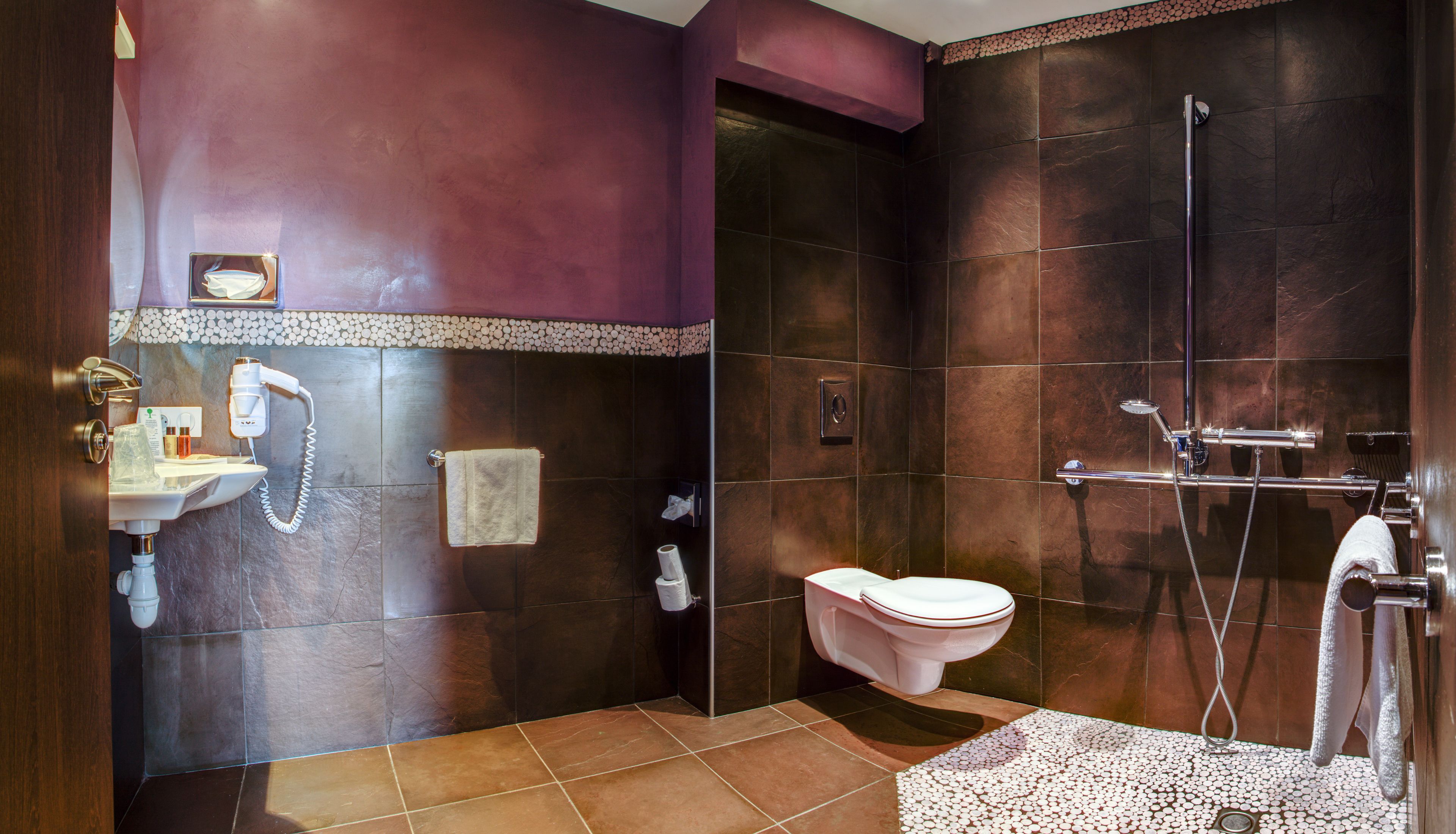 Une salle de bain équipée d’une douche, de toilettes, d’un lavabo et d’un porte-serviettes.