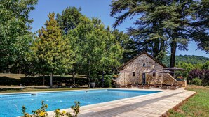 A stone building with a pool, surrounded by trees and a clear sky. - Château de la Falque, The Originals Relais  (Saint-Geniez-d'Olt-et-d'Aubrac)
