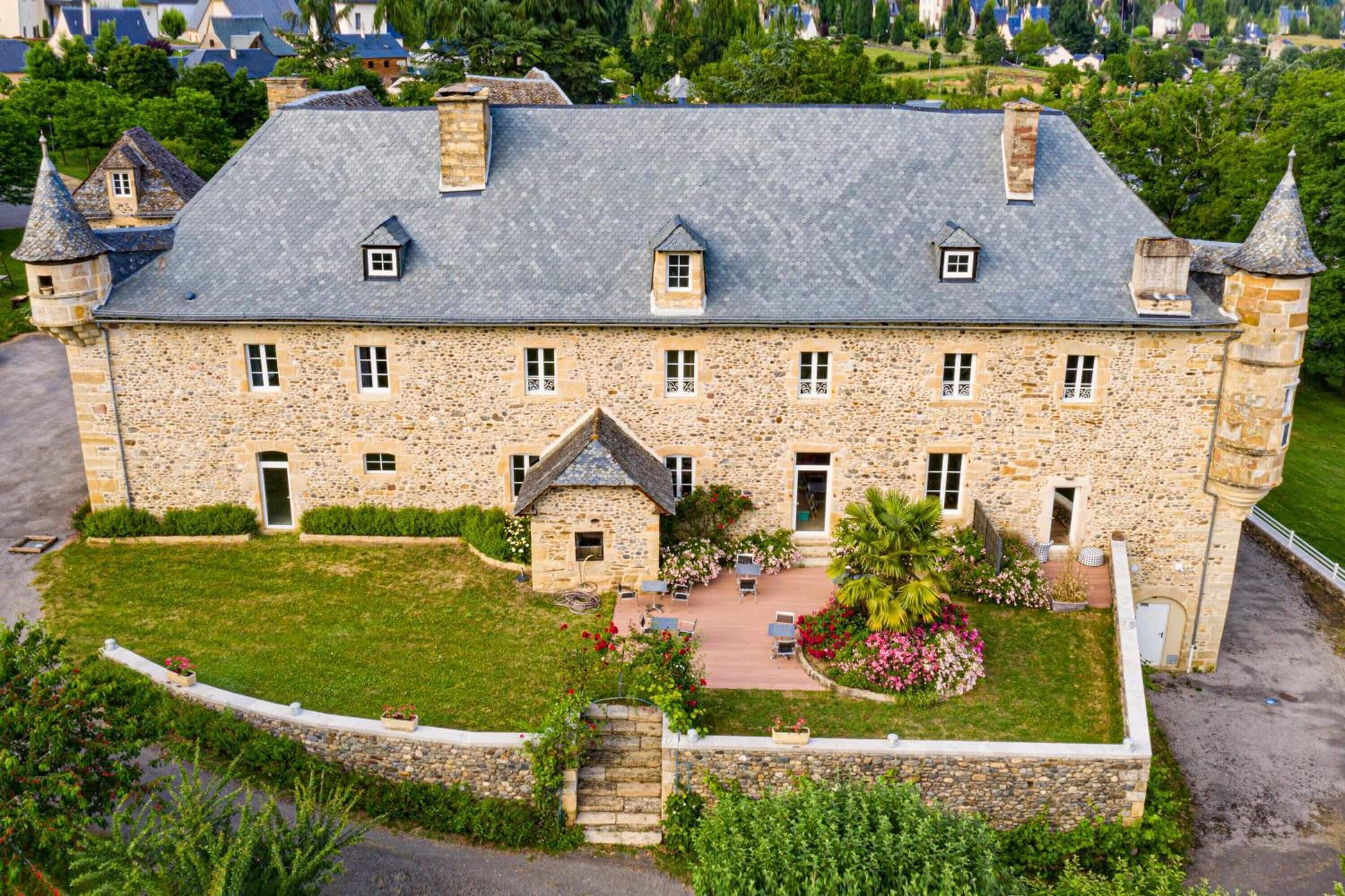 A large stone building with multiple windows and a central courtyard.