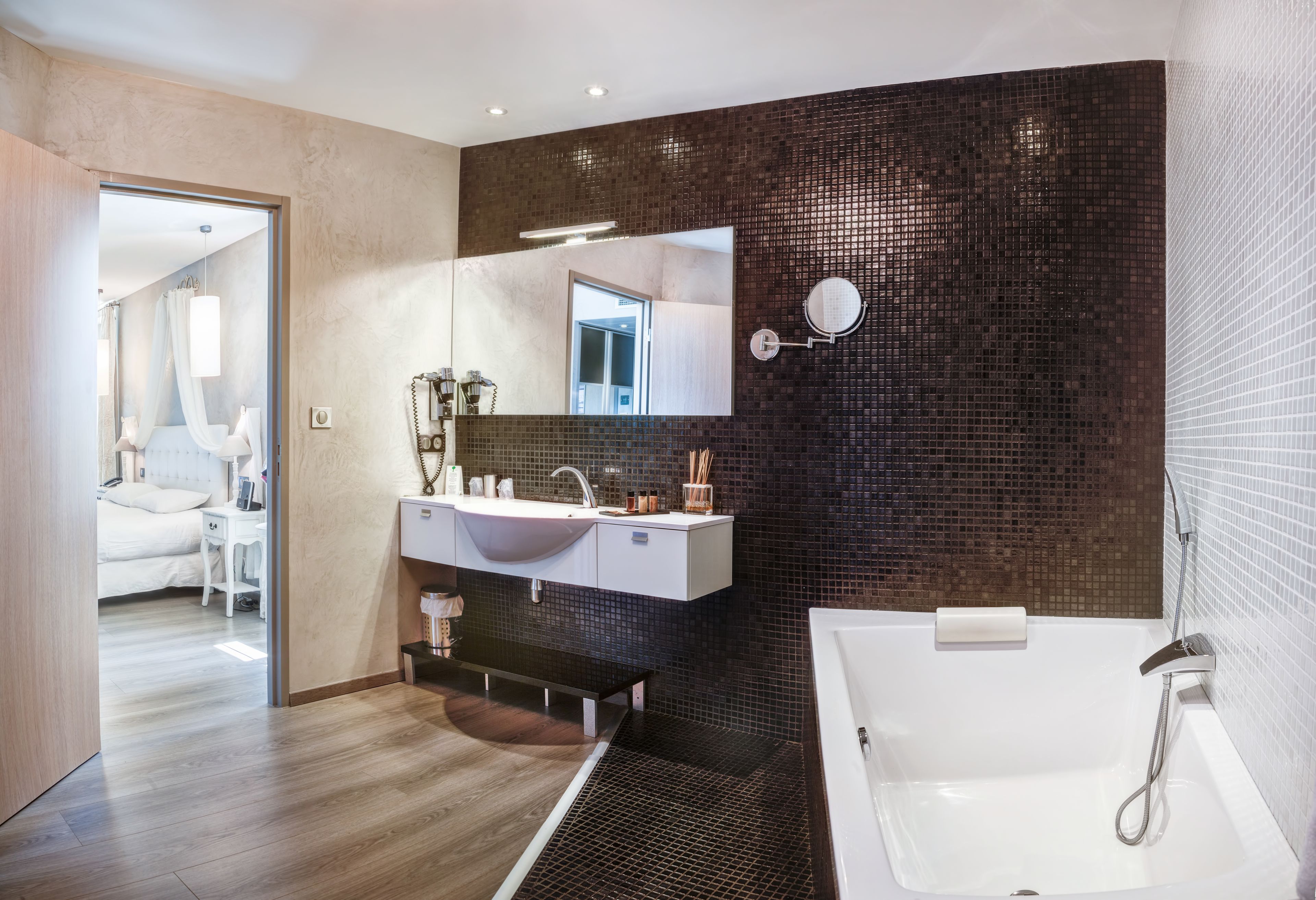 Un baño moderno con un espejo grande, dos lavamanos, una bañera y una ducha.