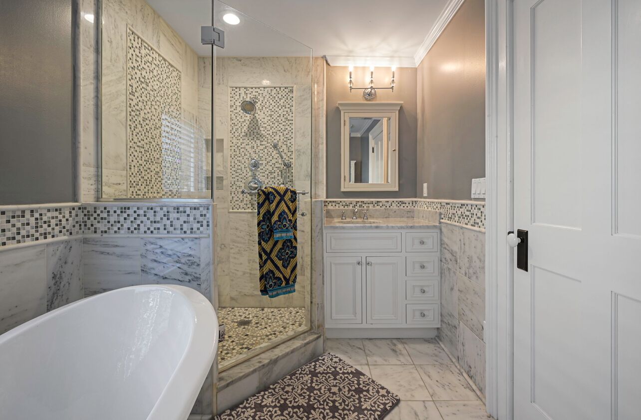 A bathroom with a freestanding bathtub, a walk-in shower, and a vanity with a mirror.