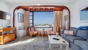 A living room with a view of the sea, a wooden cabinet, two armchairs, a sofa, and a coffee table. - Apartment the Quintero (Tías)