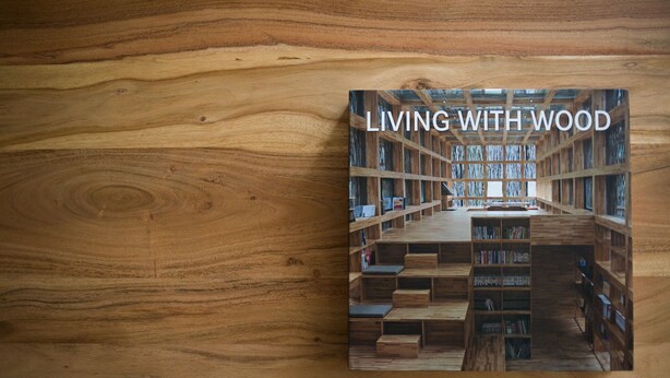 A book titled "LIVING WITH WOOD" on a wooden surface. - UPSTREET Stylish & Spacious 2BD Apt-Thiseio (Athens)