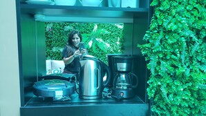 Angolo cottura con macchina del caffè, bollitore e teiera sul bancone.