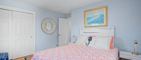 Un dormitorio con una cama, una mesita de noche y un espejo.