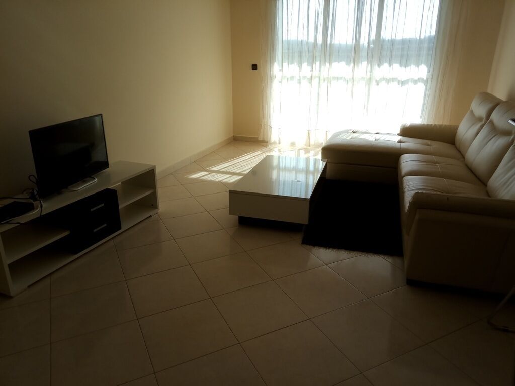 A living room with a TV, a sofa, and a coffee table.