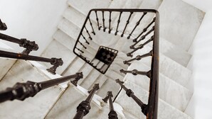 Eine Treppe mit Metallgeländern und einem Schachbrettmuster-Boden.