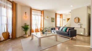 Ein Wohnzimmer mit einer Couch, einem Couchtisch und einer Topfpflanze.
