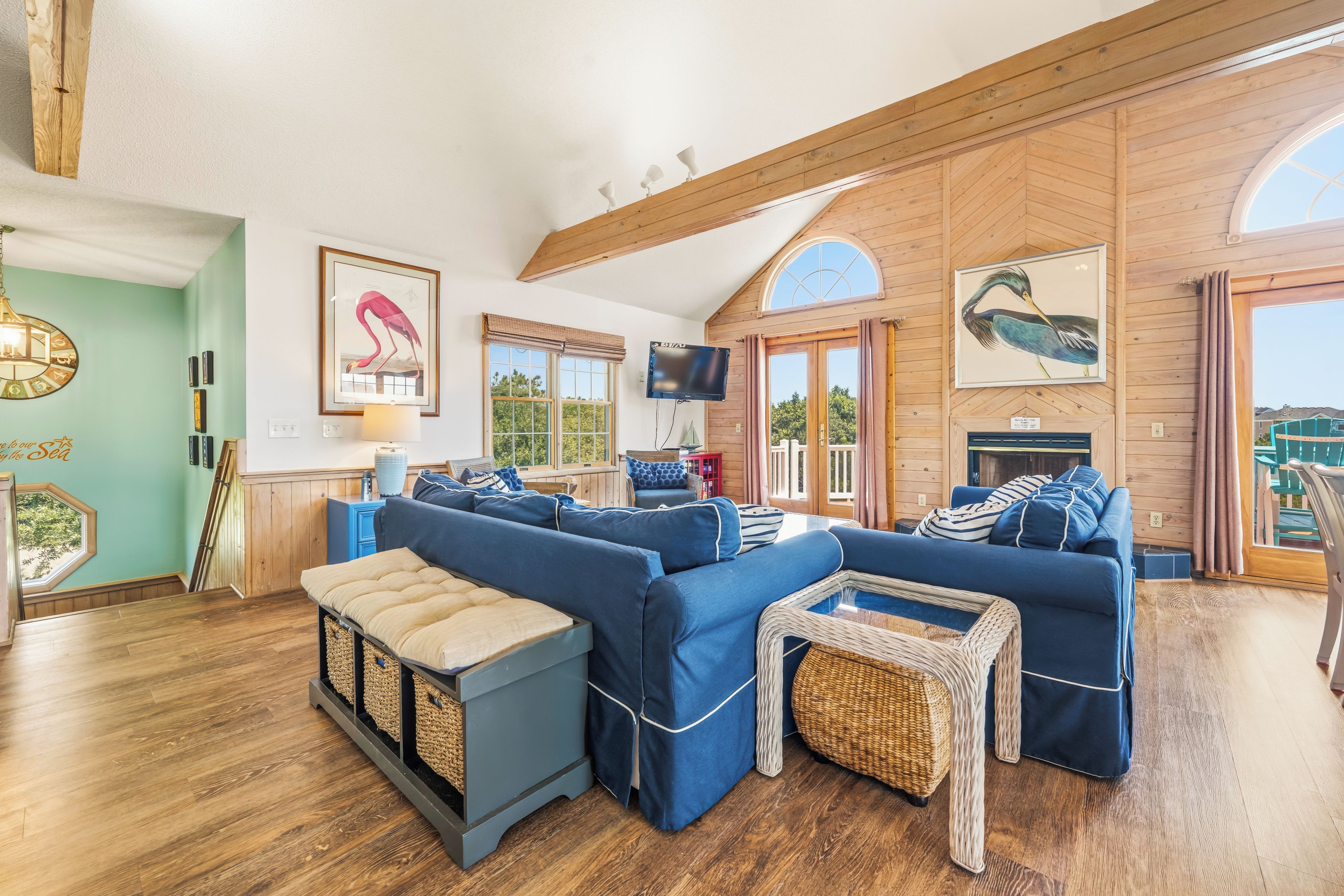 A spacious living area with a large sofa set, a television, and a fireplace.