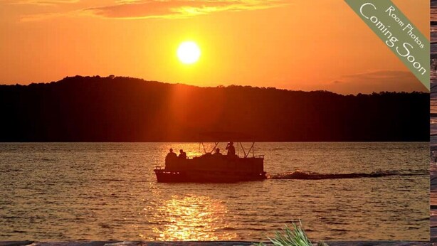 Ein Boot auf dem Wasser, im Hintergrund ein Sonnenuntergang.