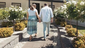 A couple walking on a pathway with a building in the background. - The Abode - Luxury, centrally located, 10 guests. (Mount Gambier)