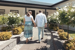 A couple walking on a pathway with a building in the background. - The Abode - Luxury, centrally located, 10 guests. (Mount Gambier)