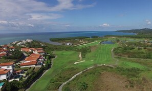 Un parcours de golf offrant une vue sur l’océan et les immeubles résidentiels.