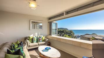 Departamento Premium, varias camas, vista al océano | Área de sala de estar | Televisión