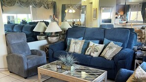 A living room with a blue sofa, a glass coffee table, and a grey armchair. - Newly Re-decorated, 4 Recliner's Oceana, On the beach front, downtown Rosarito. (Centro Playas)