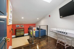 A modern room with a bed, a desk, and a TV.