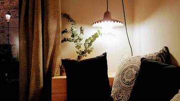 Una habitación acogedora con una cama, una lámpara colgante y una planta en maceta.