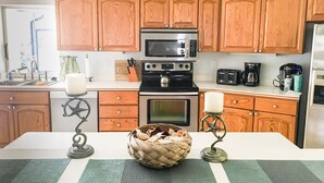Una cucina con mobili in legno, un forno a microonde, un tostapane e una macchina da caffè.