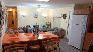 A dining area with a wooden table, wicker chairs, and a ceiling fan. - Key largo waterfront jewel (Key Largo)
