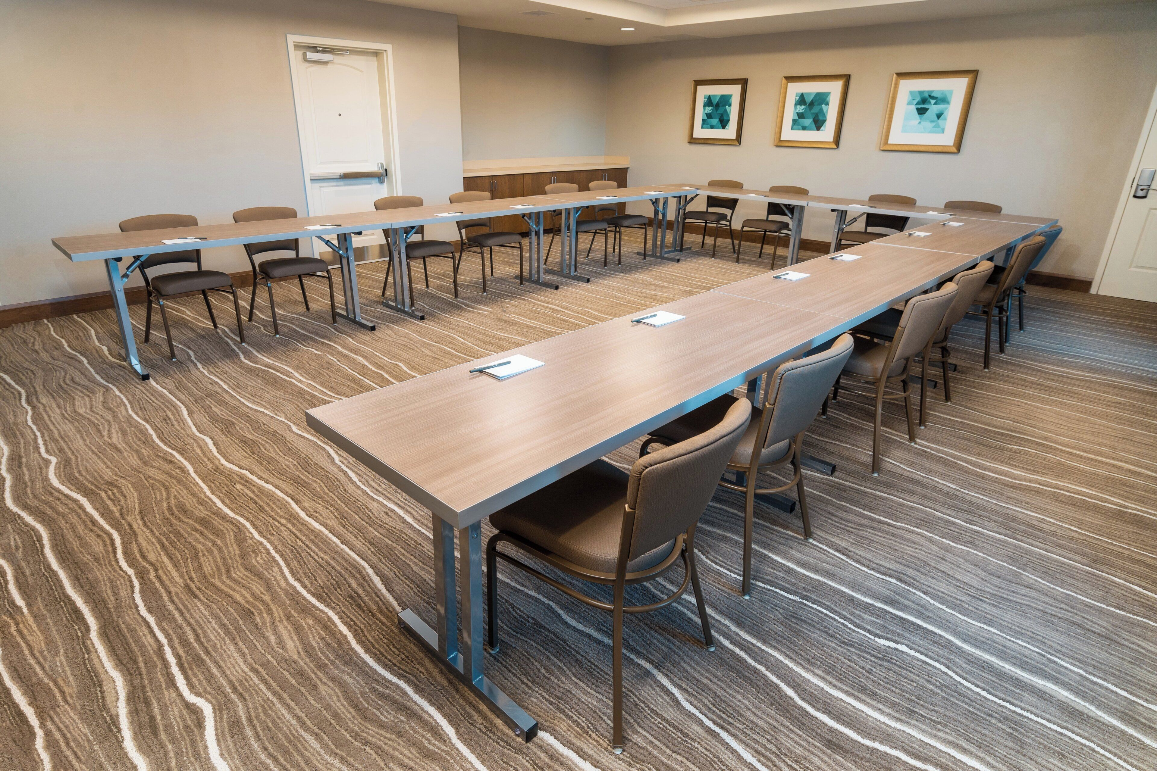 A conference room with a long table, chairs, and a whiteboard.