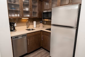 Une cuisine moderne dotée d’appareils électroménagers en acier inoxydable, de meubles en bois et d’un lave-vaisselle.