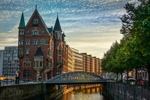 Un edificio histórico con una torre destacada y un puente sobre un canal.