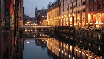 Un canal flanquejat d'edificis, un pont i llums de Nadal reflectint a l'aigua.