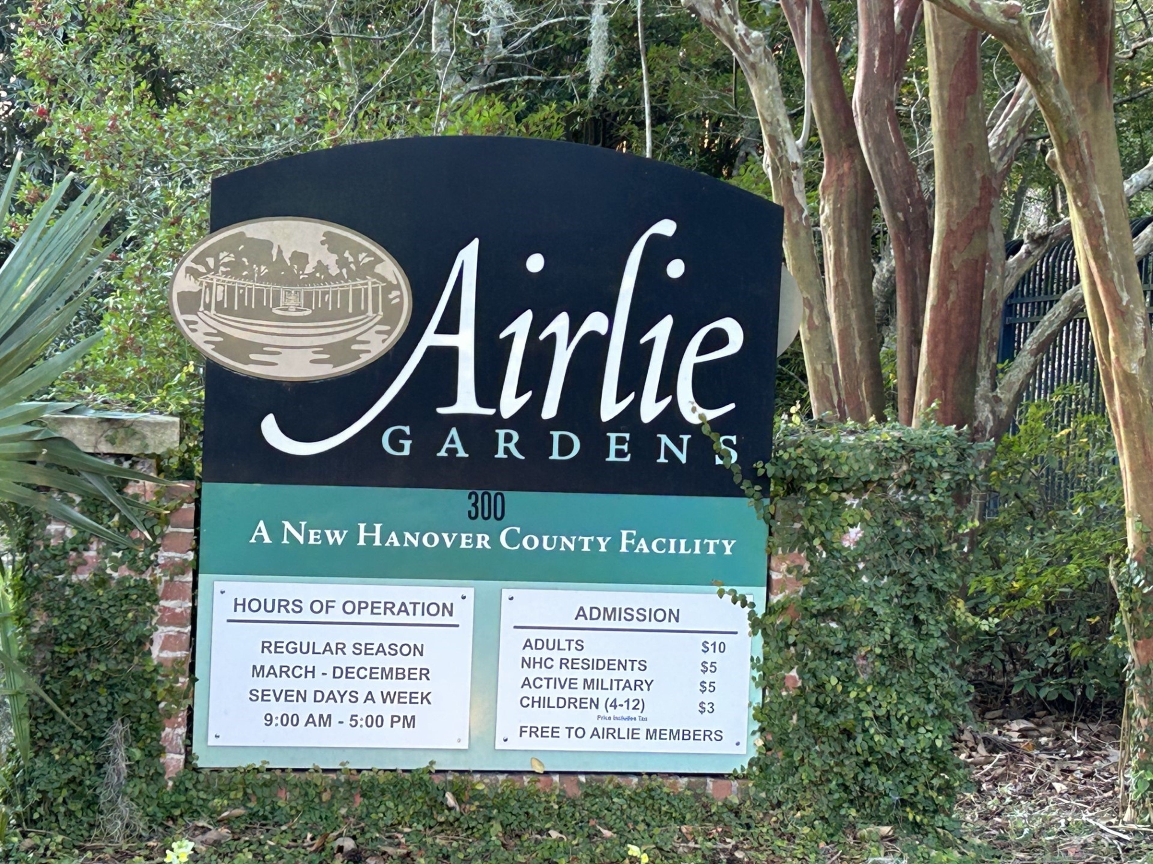 Señal de Airlie Gardens, instalación del condado de Nuevo Hanover, con precios de admisión y horario de apertura.