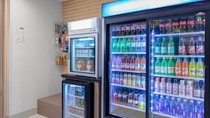 Zona de máquinas expendedoras con diversas opciones de bebidas, como refrescos y aperitivos.