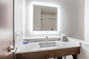 Un baño moderno con un espejo grande, un lavabo y un perchero para toallas.