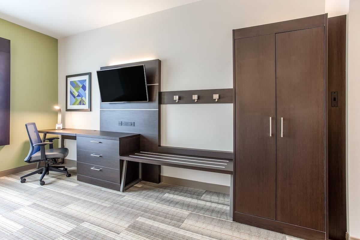 A modern office space with a desk, chair, and wardrobe.