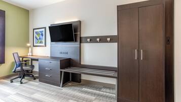 A modern office space with a desk, chair, filing cabinet, and a large wardrobe.