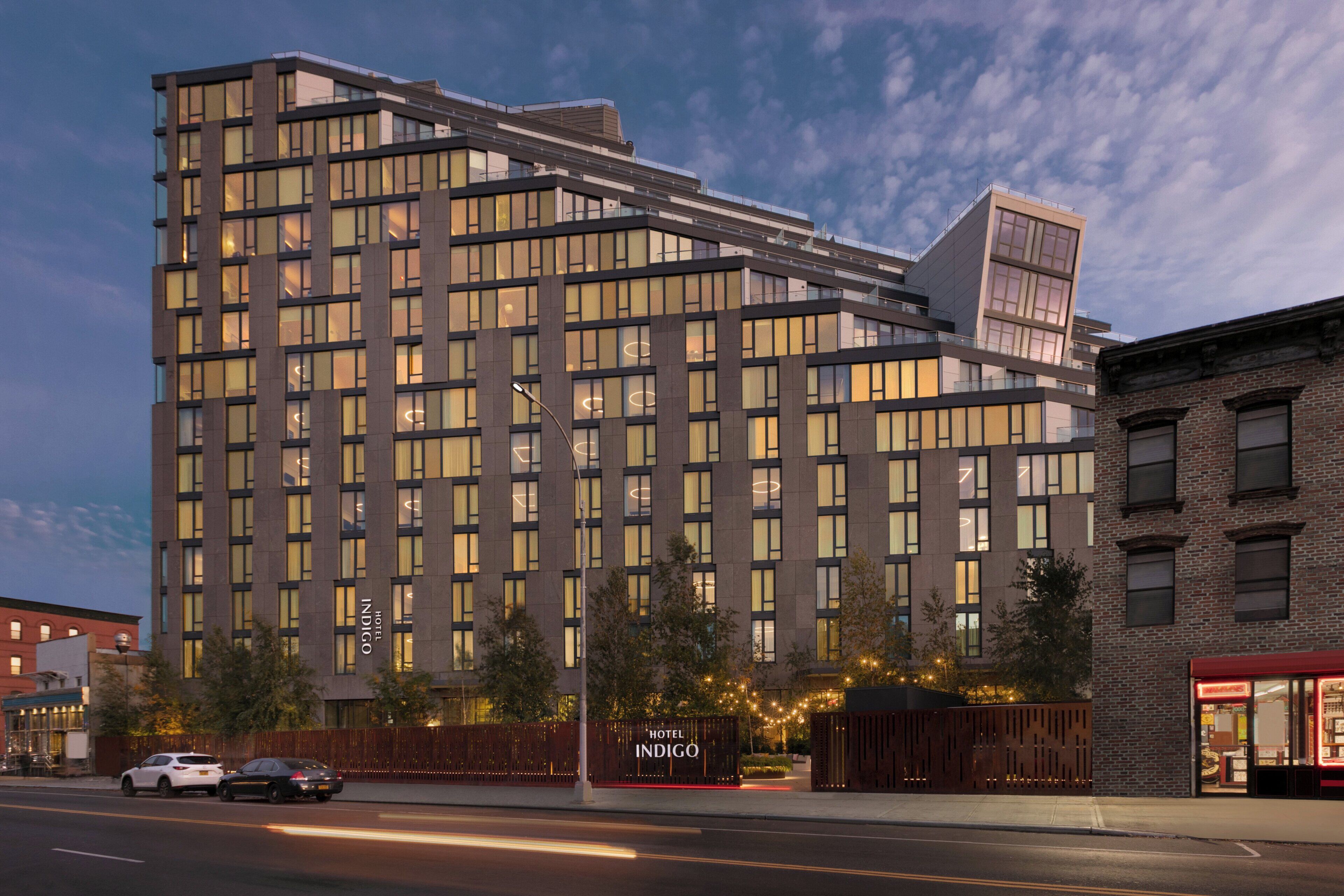 A modern hotel building with multiple floors, large windows, and a prominent entrance.