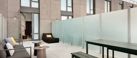 An outdoor seating area with a sofa, a bench, and a small table.