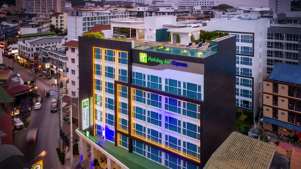 Een Holiday Inn Express hotel met een zwembad op het dak, omringd door stadsgebouwen.