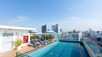 Una piscina al aire libre, sillones reclinables de piscina