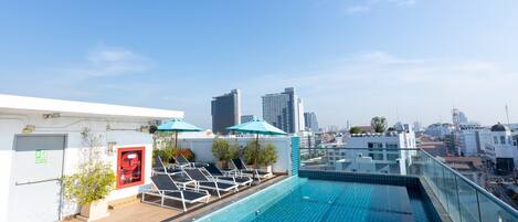 Una piscina al aire libre, tumbonas