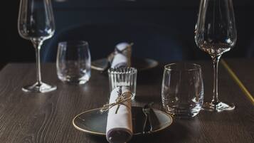 Uma mesa posta com um prato, um guardanapo, um copo e uma taça de vinho.
