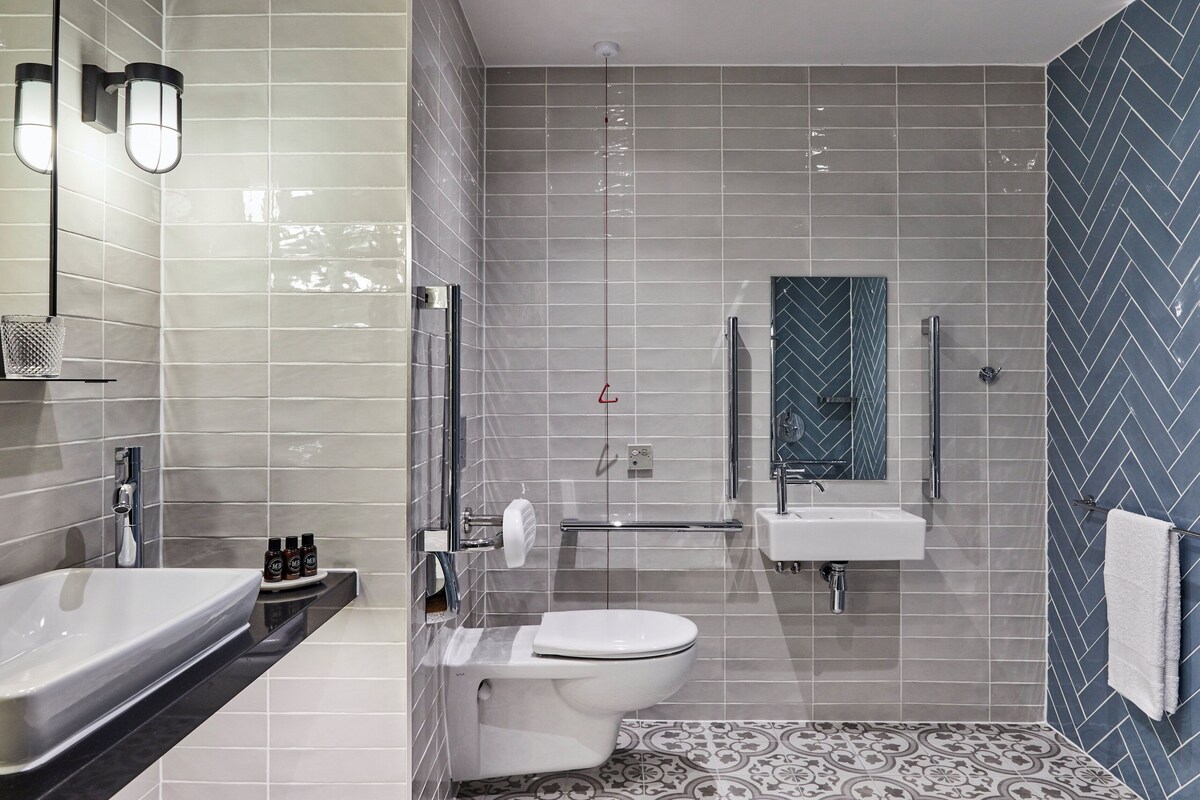 A modern bathroom with a toilet, sink, and shower area.